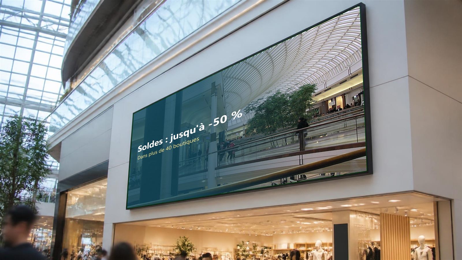 Grand écran mural dans une galerie marchande annonçant les soldes